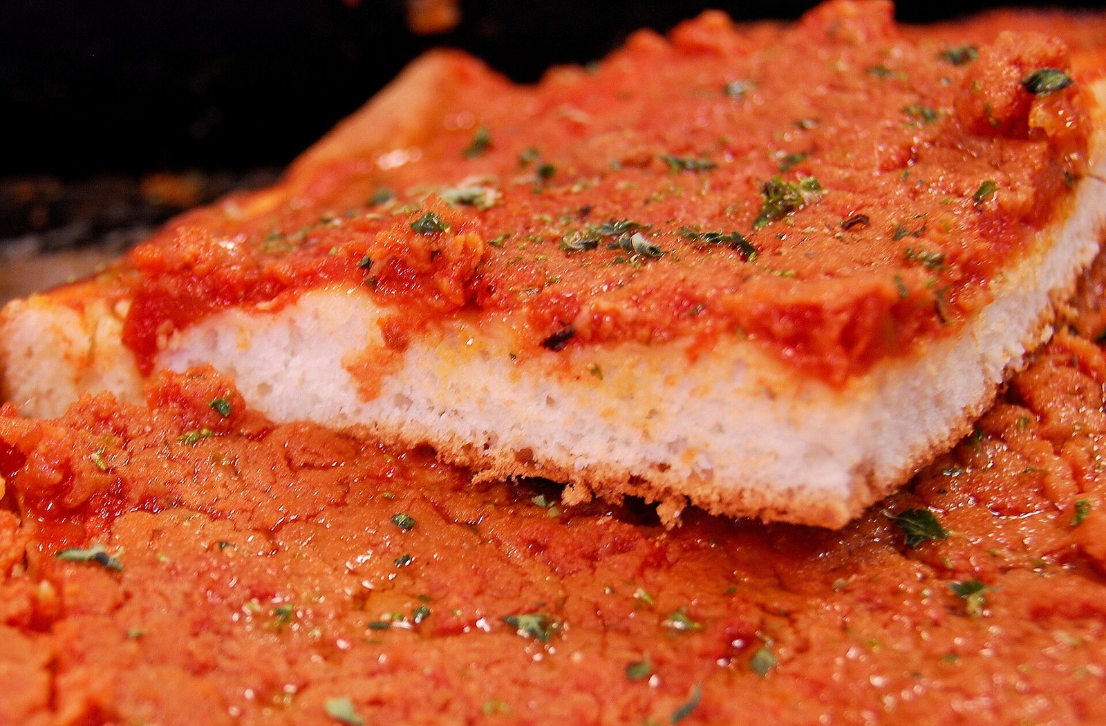 Fetta di sfincione palermitano con pomodoro e origano